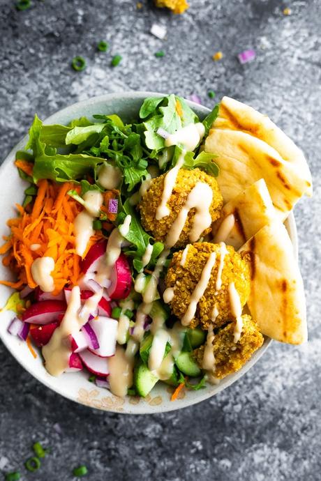 overhead view of falafel salad bowls drizzled with tahini sauce