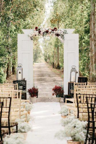 rustic wedding ideas outdoor ceremony with white doors and flower aidle and lanterns jessica bordner photography