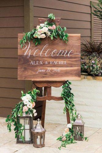 rustic wedding ideas welcome sign board secorated with greenery and lanterns valorie darling photography