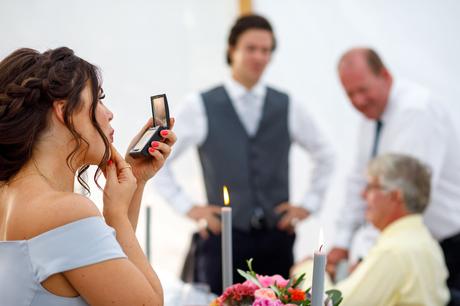 Summer Solstice Wedding – Polly and Steve a bridesmaid touches up her makeup