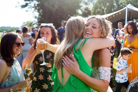 Summer Solstice Wedding – Polly and Steve the bride hugs one of her friends