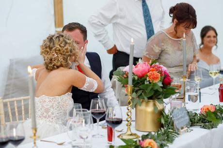 Summer Solstice Wedding – Polly and Steve bride and groom kiss at the top table