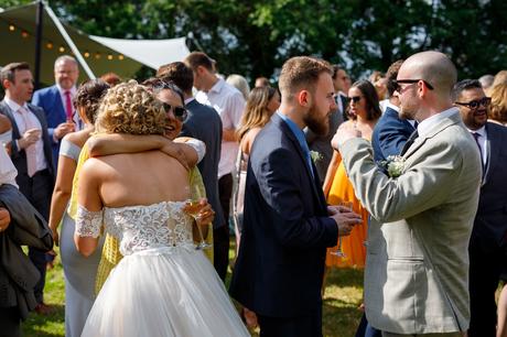 Summer Solstice Wedding – Polly and Steve the bride hugs one of her guests