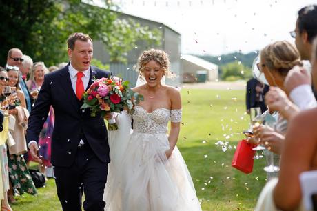 Summer Solstice Wedding – Polly and Steve bride and groom walk through the confetti