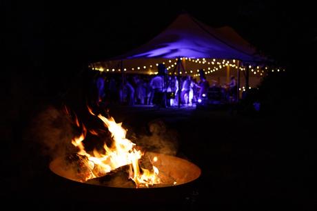 Summer Solstice Wedding – Polly and Steve a firepit with the wedding marquee in the background
