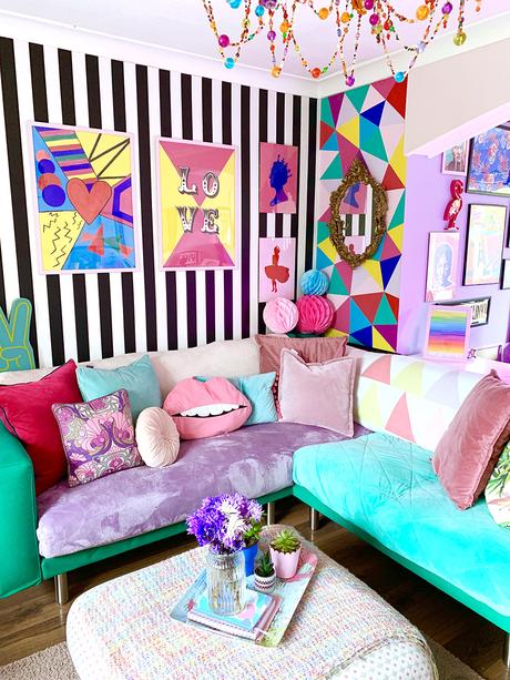 Crazy & colourful living room decor with monochrome stripy wallpaper and quirky color pops.
