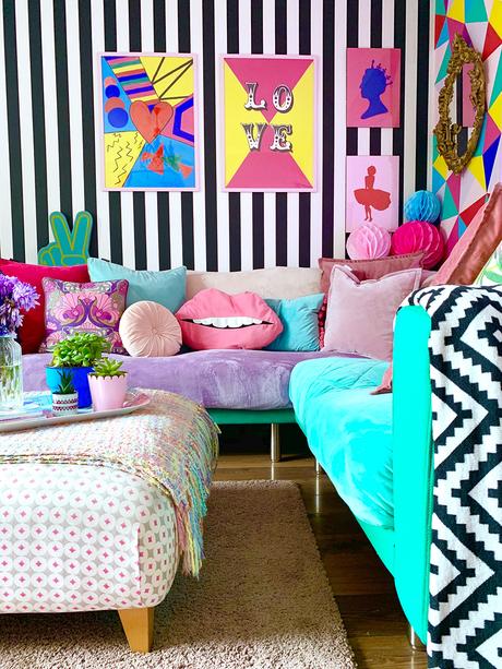 Crazy & colourful living room decor with monochrome stripy wallpaper and quirky color pops.