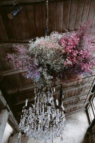 wedding ideas elegant chandelier in the barn and pastel colored hanging flowers ilbaccellodivaniglia