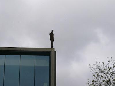 Image of art work by Anthony Gormly of statute on a rooftop