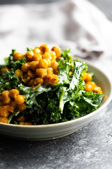 close up view of kale caesar salad in a gray bowl