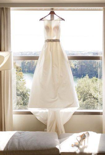 hanging wedding dress dress near window jennydemarcoweddings 