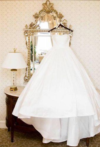 hanging wedding dress dress on the morror cristinagphoto