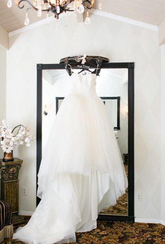 hanging wedding dress dress on the mirror leahmariephotography
