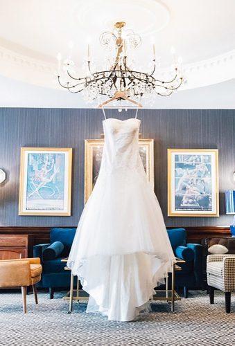 hanging wedding dress dress on chandelier heathereastphoto