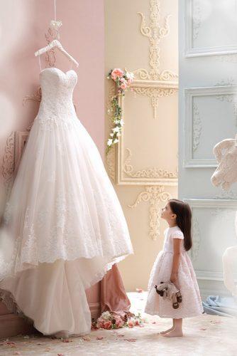 hanging wedding dress little girl look at dress moncheribridals