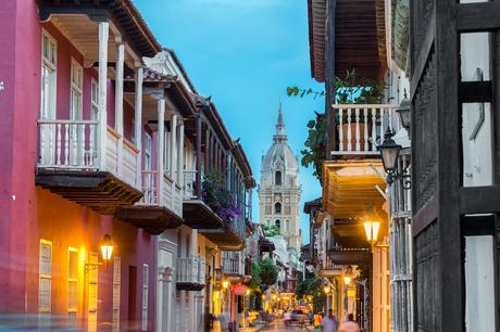 Street view of Cartagena, Colombia after sunset with cathedral visible in the background
