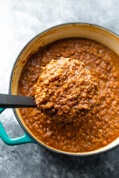 overhead shot of a spoon scooping the vegan pasta sauce out of a pot