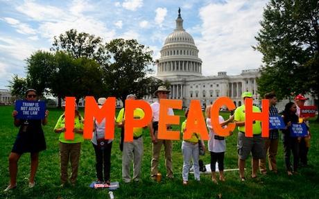Protesters hold up letters reading 'impeach' in front of the US Capitol
