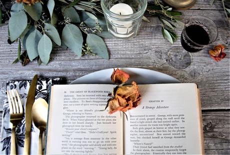 a Halloween tablescape with a mystery book theme a Halloween tablescape with a mystery book theme
