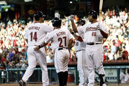 The old Carlos Lee congratulates the new faces of the Astro Franchise JD Martinez and Jose Altuve  (Photo by Bob Levey/Getty Images)