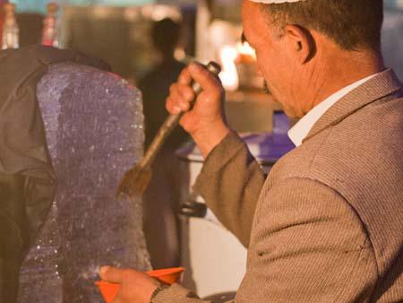 Uighur man shaving ice for dessert durap