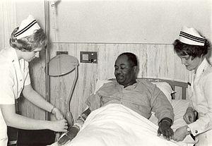 Navy nurses attending to a patient, 1960s.