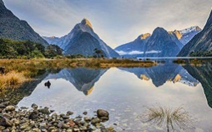 Enchanting Travels New Zealand Tours First light on Mitre Peak and surrounding mountains at Milford Sound