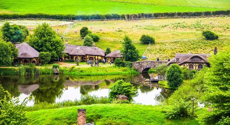 Enchanting Travels New Zealand Tours Summer river village in Shire, Hobbiton, New Zealand. Hobbit houses at river in Hobbiton, New Zealand