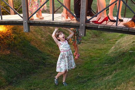 100 Best Barn Wedding Photos a cheeky girl under the bridge at a barn wedding