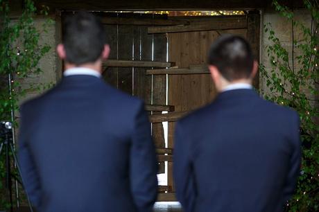 100 Best Barn Wedding Photos the groom and best man wait for the bride to come through the barn doors