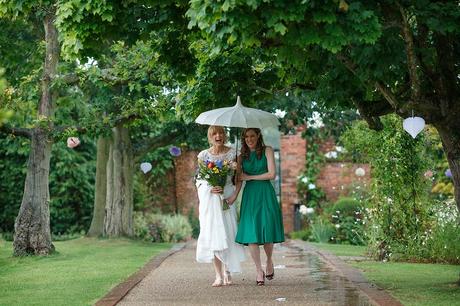 100 Best Barn Wedding Photos a bride and bridesmaid walk through the rain at gaynes park