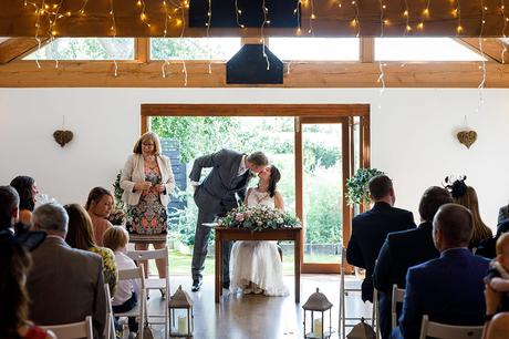 kissing during a maidens barn wedding ceremony