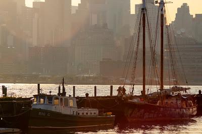 A small motor launch and a small schooner tied up at a dock in Hoboken in the early morning