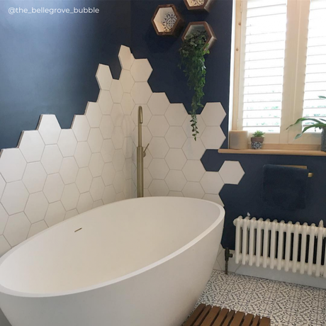 low level white column radiator in a blue bathroom