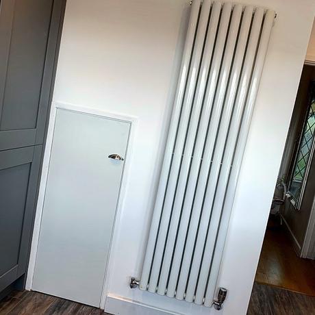 white vertical radiator on a white wall