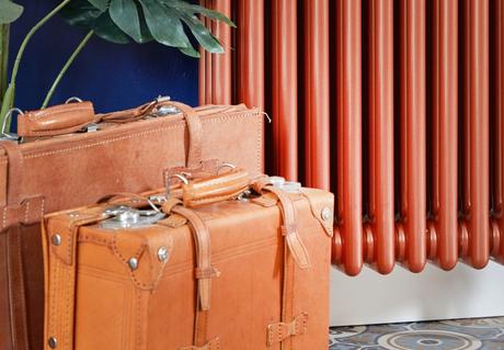 Milano Windsor copper vertical radaitor next to suitcases