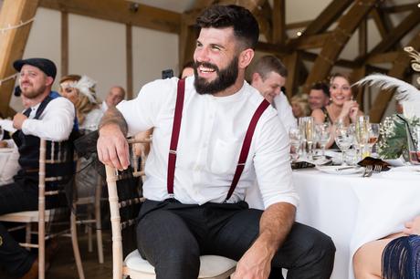 Guest with beard & braces laughing during speeches at Sandburn Hall Wedding. 