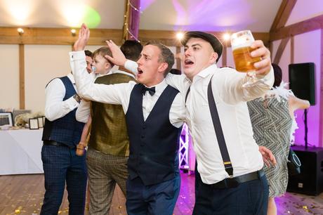 Guests dancing with arms around each others shoulders at York wedding. 