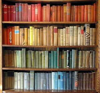 A bookshelf containing books arranged by colour