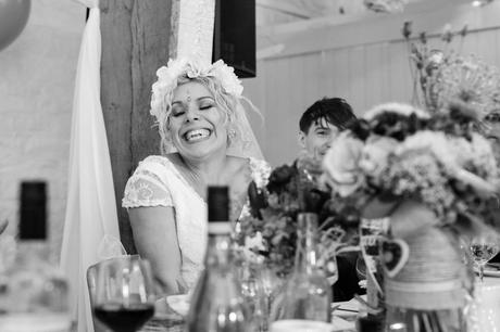 Bride smiles sweetly during speeches at East Riddlesden Hall. 