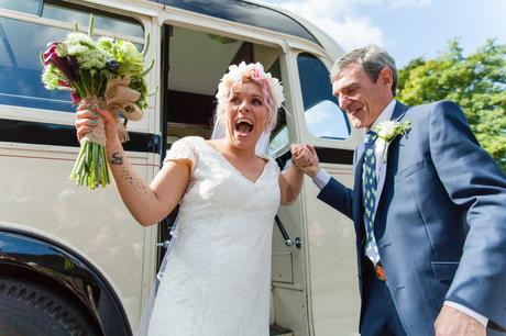 Bride has a huge, happy smile as she exits the bus for her wedding at East Riddlesden Hall. 