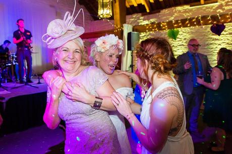 Bride hugs mom on dance floor at East Riddlesden Hall wedding. 