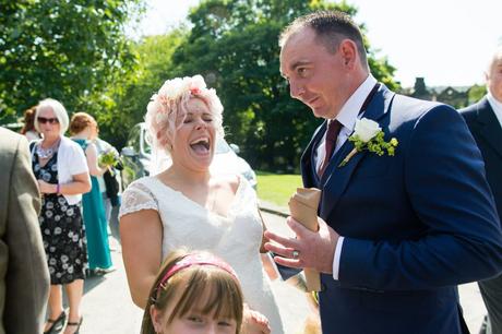 Bride smiles and laughs with guest at East Riddlesden Hall