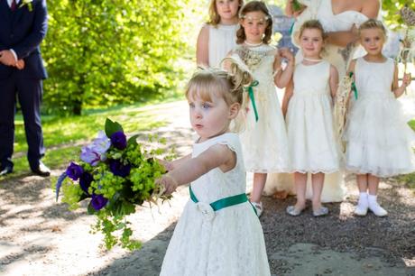 Little flower girl running away during group photos at Yorkshire wedding. 