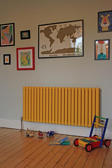 yellow radiator in a playroom with toys on the floor