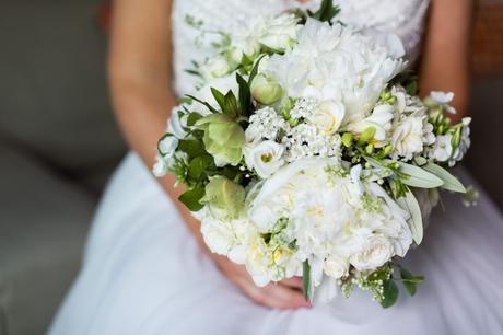 Bride holds all-white wedding bouquet with peonies at Asylum wedding. 