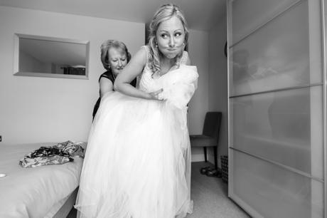 Bride makes hilarious face when putting on wedding dress. 