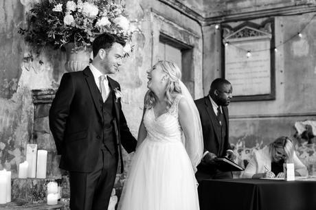 Bride and groom look at each other and smile/laugh at London Asylum wedding. 