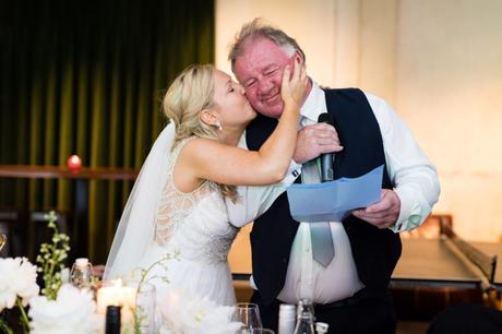 Bride kisses dad on the cheek during speeches at London wedding. 