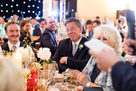 Guest makes funny face during wedding speeches. 